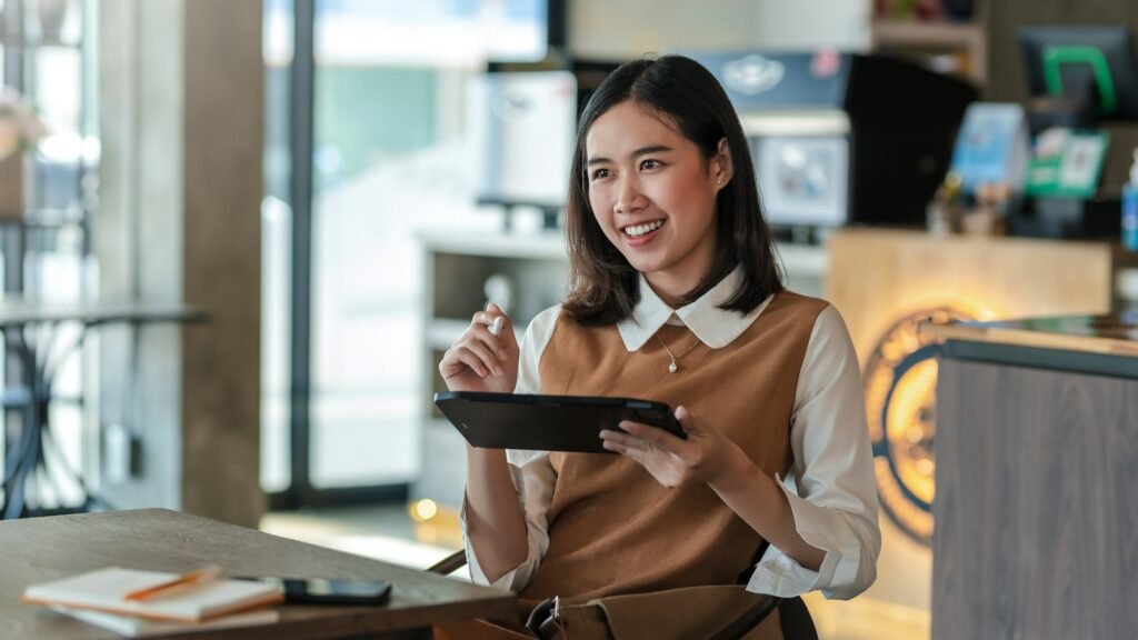 Beautiful smiling happy businesswoman holding a stylus with a tablet at café.